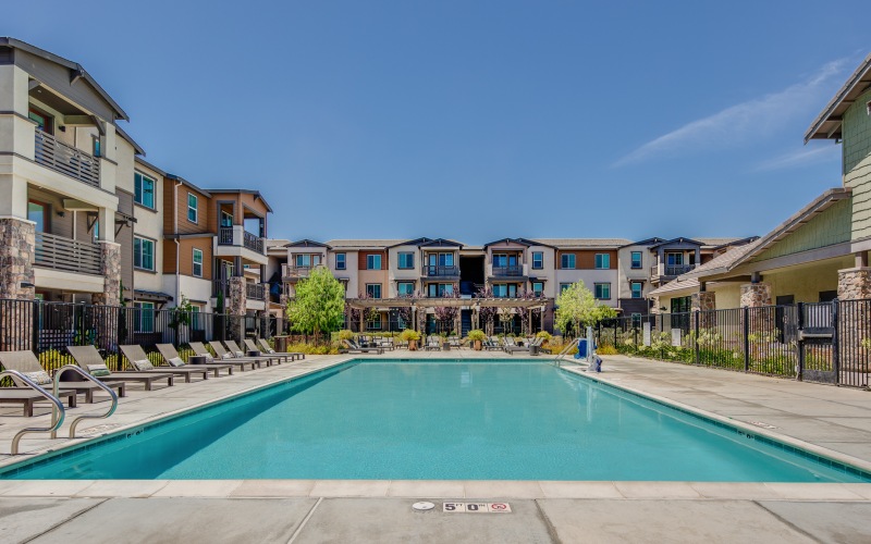 Brentwood apartments with large pool are and chairs 